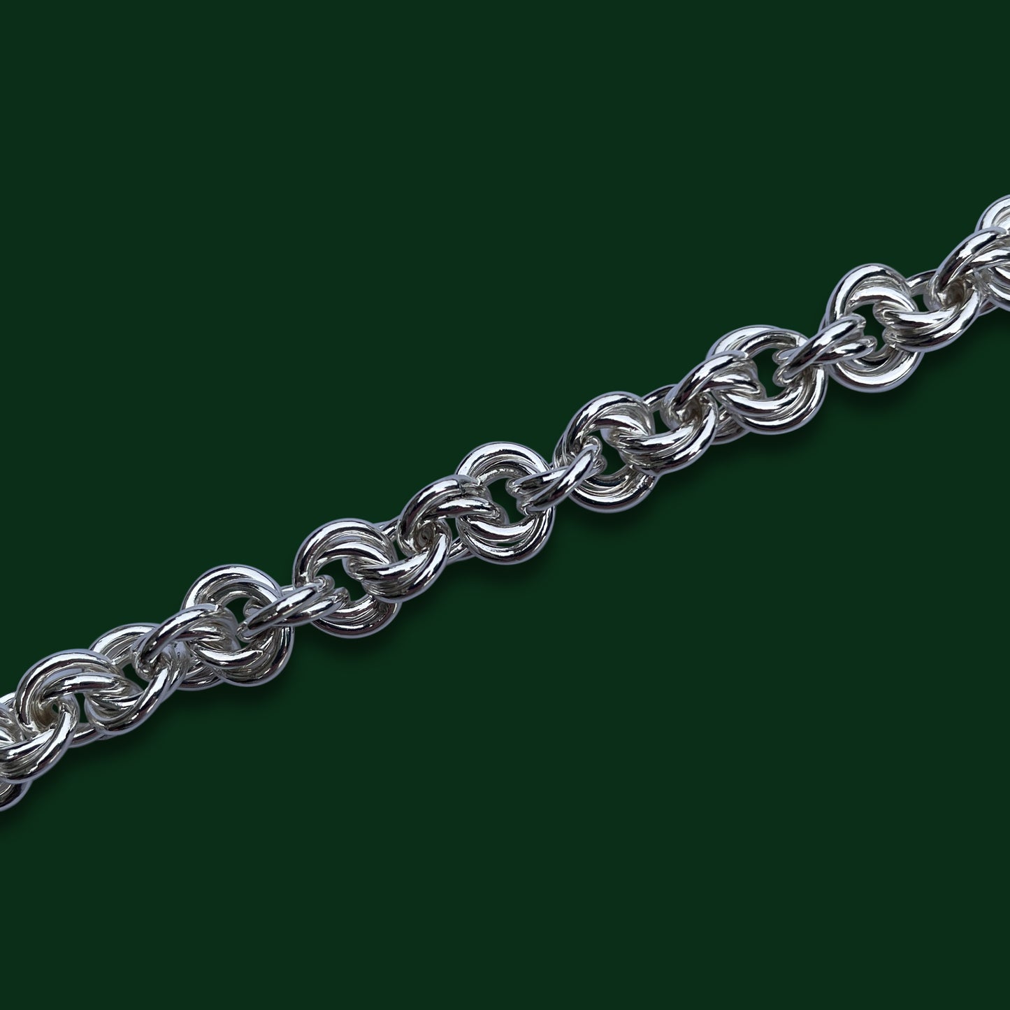 Close up of the interlocking layered rings of the Agora design on a dark green background.