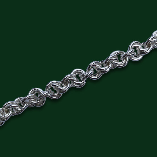 Close up of the interlocking layered rings of the Agora design on a dark green background.