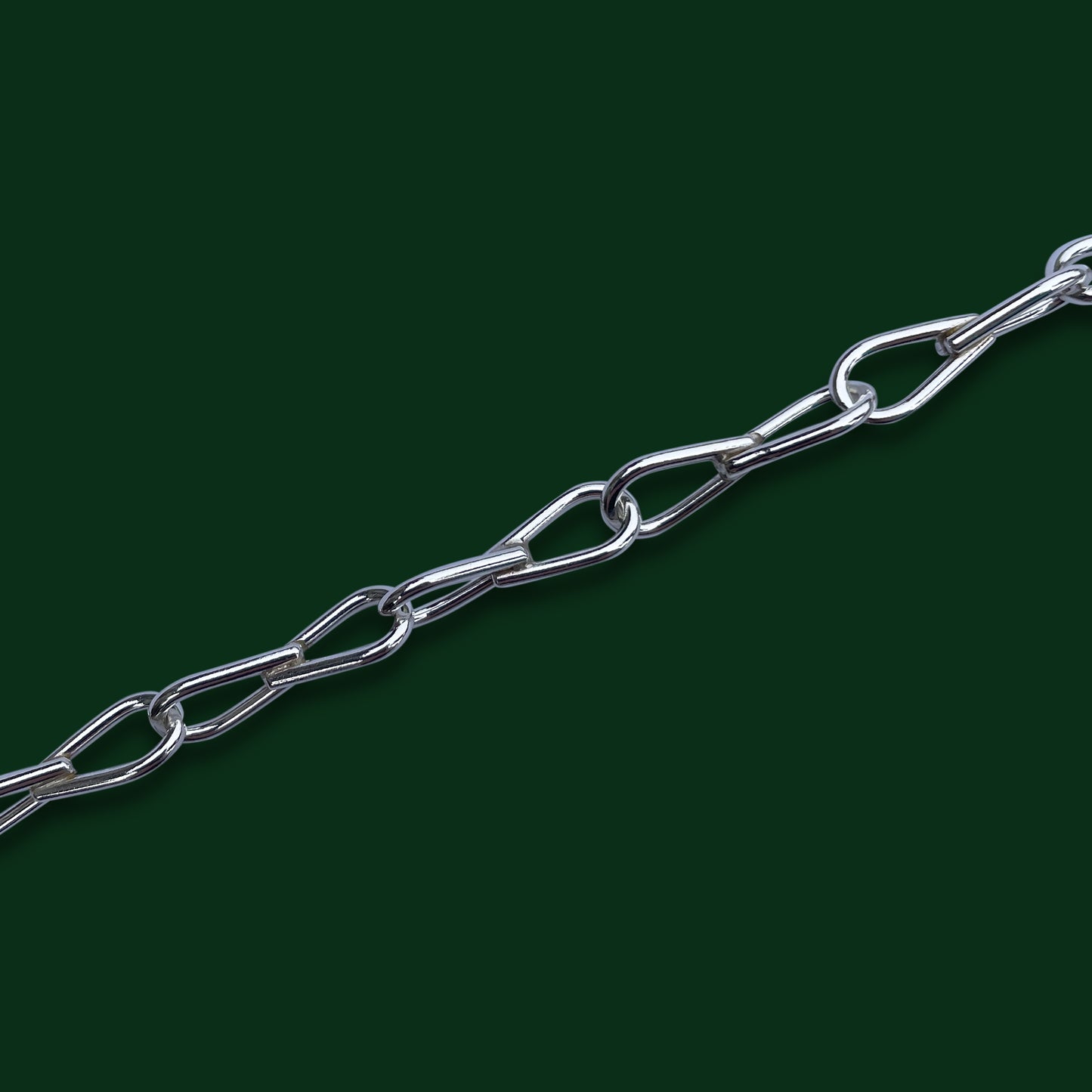 A close up of Timio's Ekko chain with its mirroring tear drop-shaped links on a dark green background.